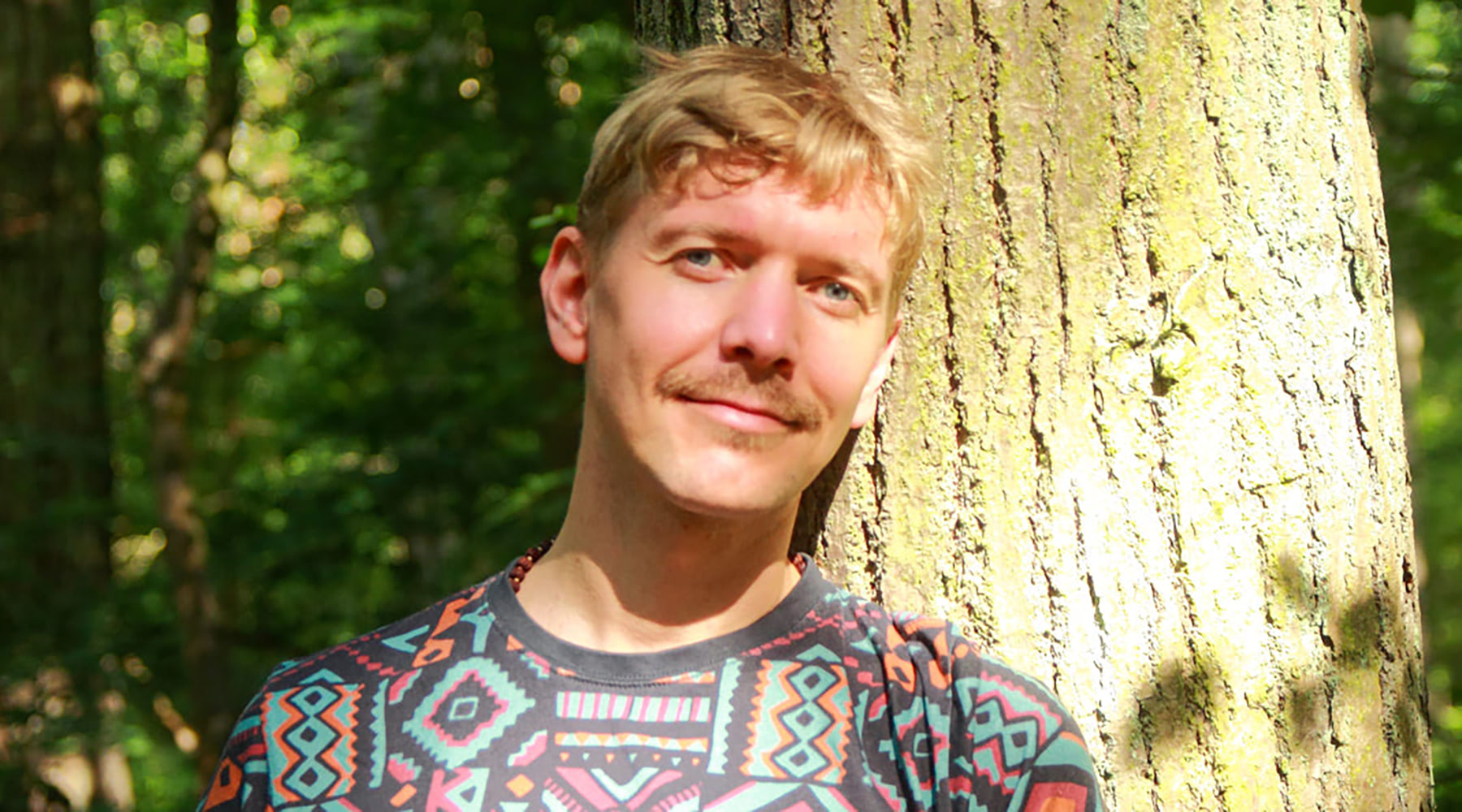 Portrait von Eric Böge vor einem Baum